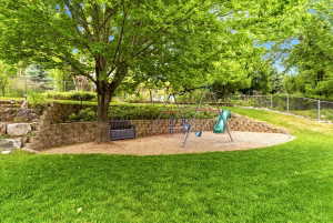 Private, fully fenced backyard with covered patio, shade trees, play area, swingset and RV parking