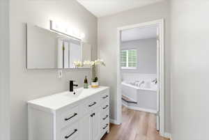Spacious primary suite with a walk in closet, double vanity, and separate jetted tub and shower