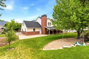 Private, fully fenced backyard with covered patio, shade trees, play area, swingset and RV parking