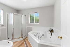 Spacious primary suite with a walk in closet, double vanity, and separate jetted tub and shower