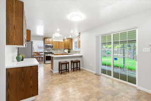 Kitchen leads to covered patio and shaded backyard, a wonderful place for entertaining!
