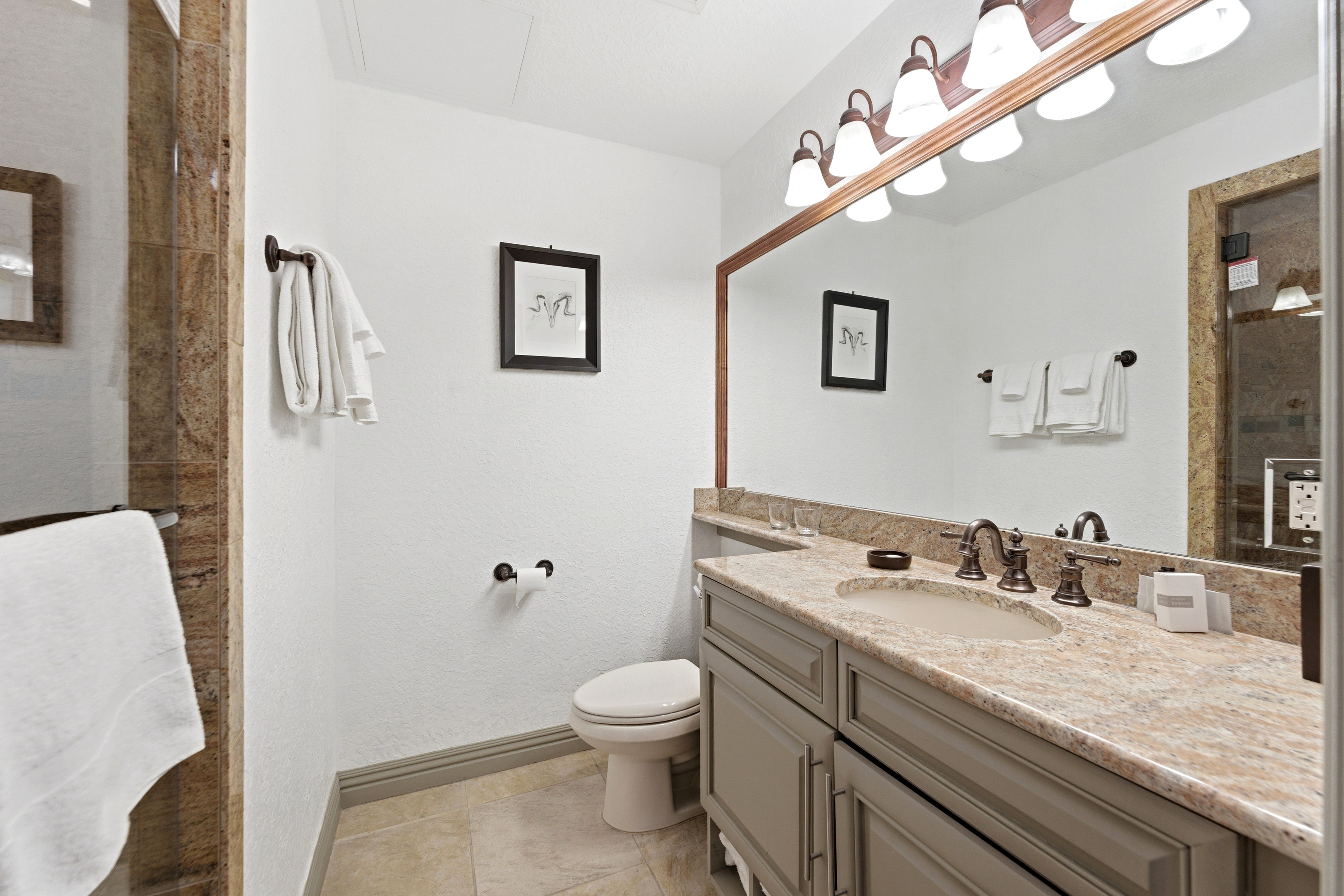 Bathroom featuring a vanity with a light-toned countertop, integrated sink, and bronze-finish fixtures