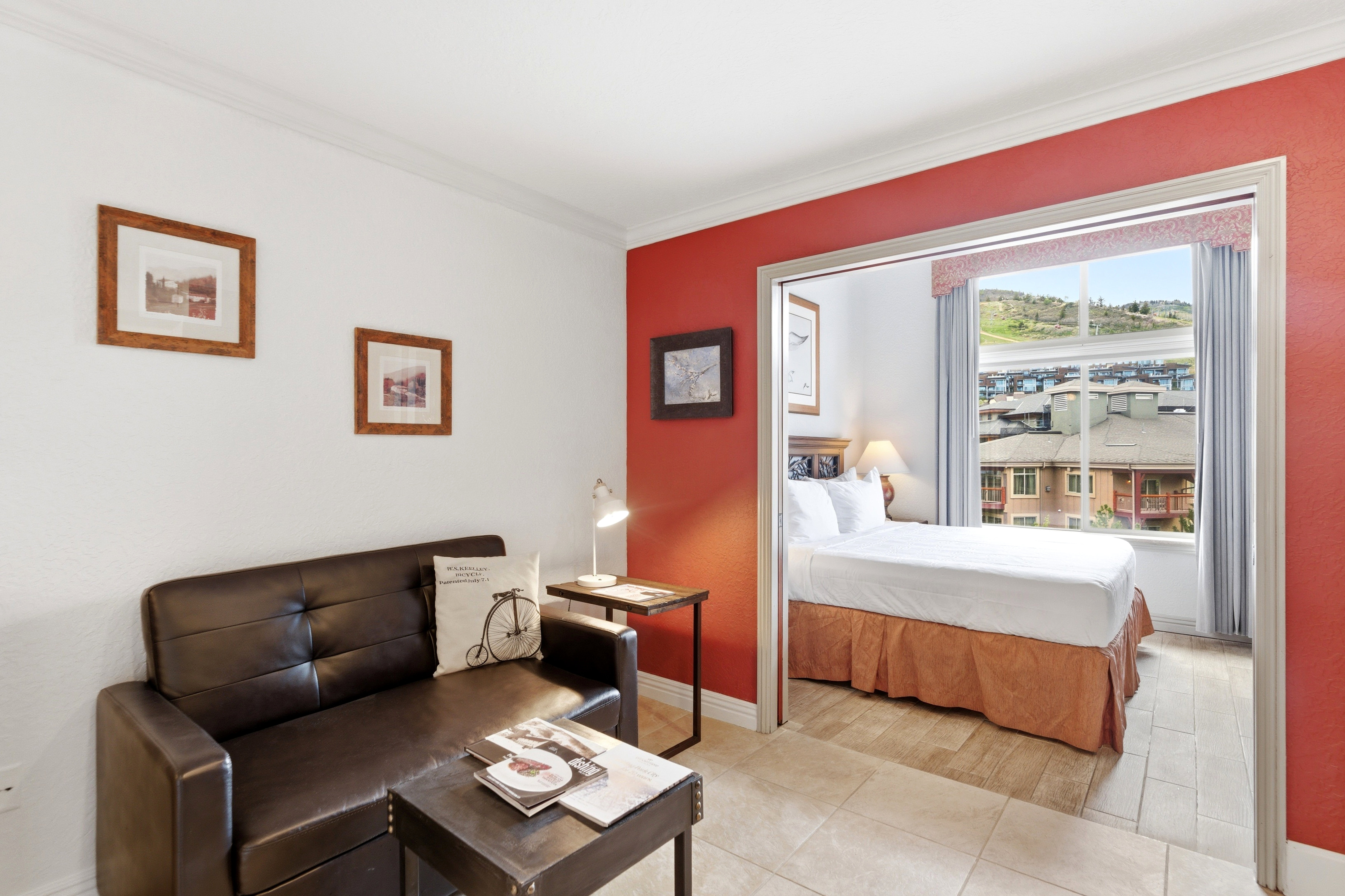 Bright interior space featuring a red accent wall and neutral toned tile flooring
