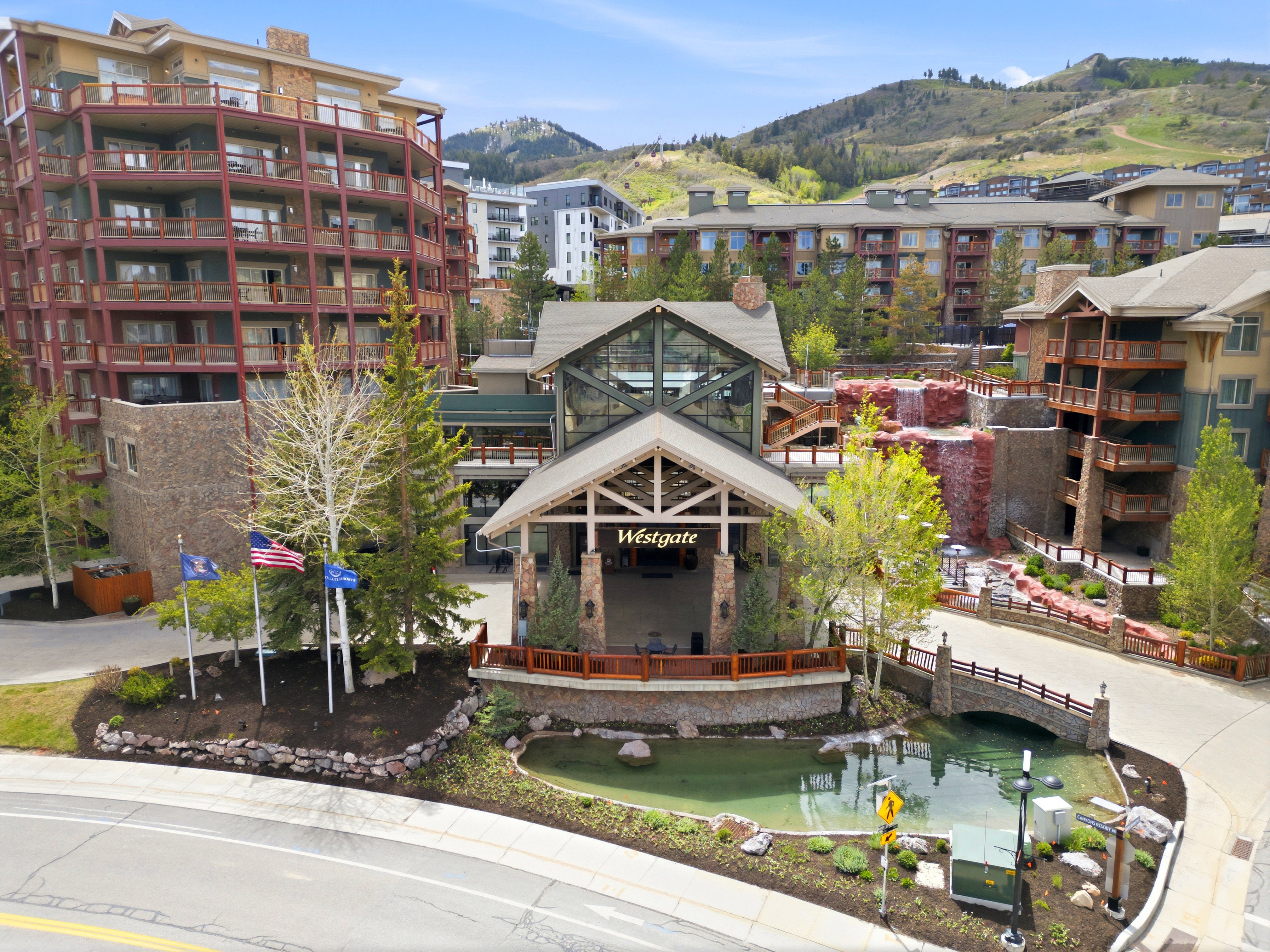 Multi-story building featuring extensive balconies, a prominent main entrance, and stone accents