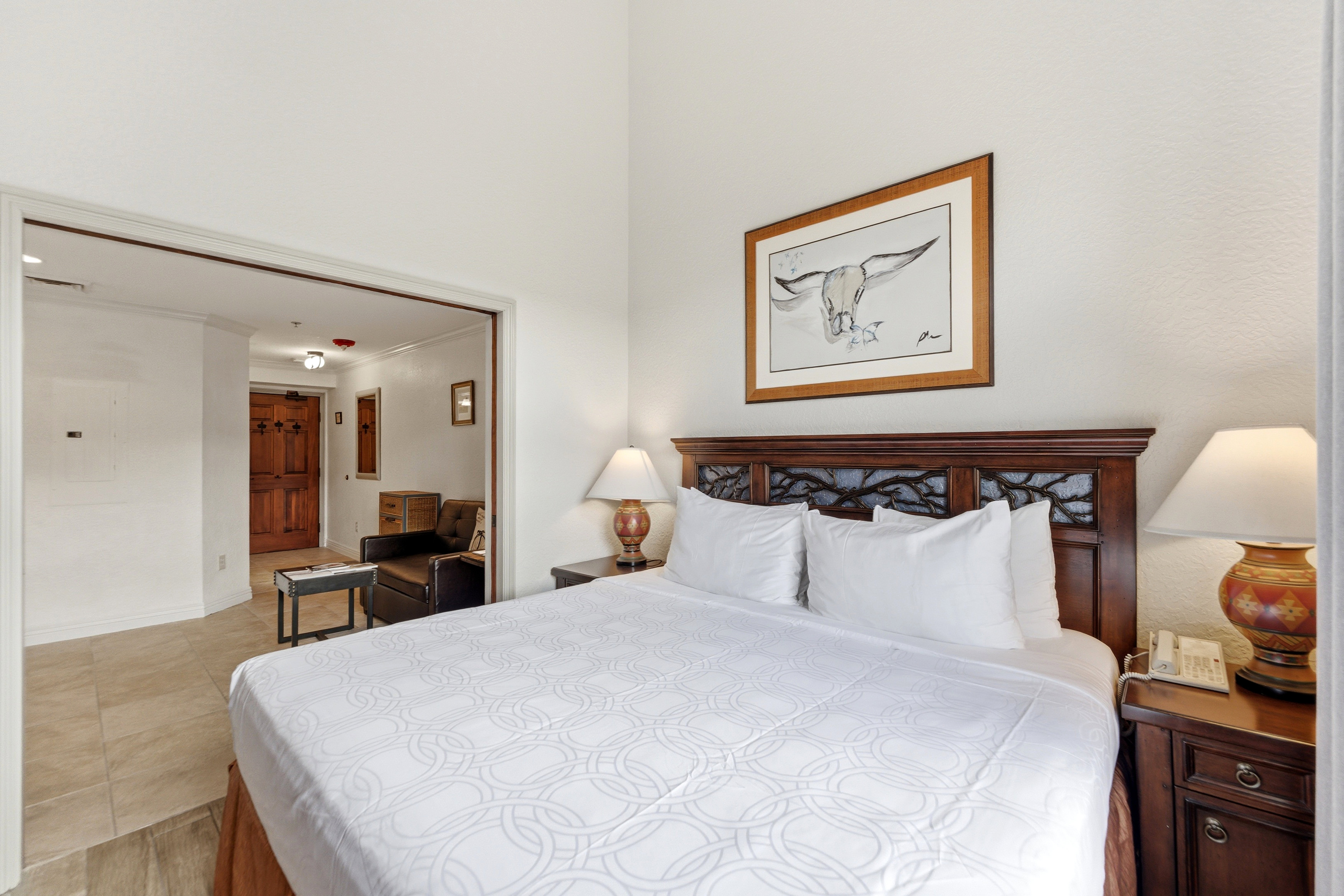 Bedroom featuring a dark wood headboard with carved detailing, neutral wall paint, and recessed lighting