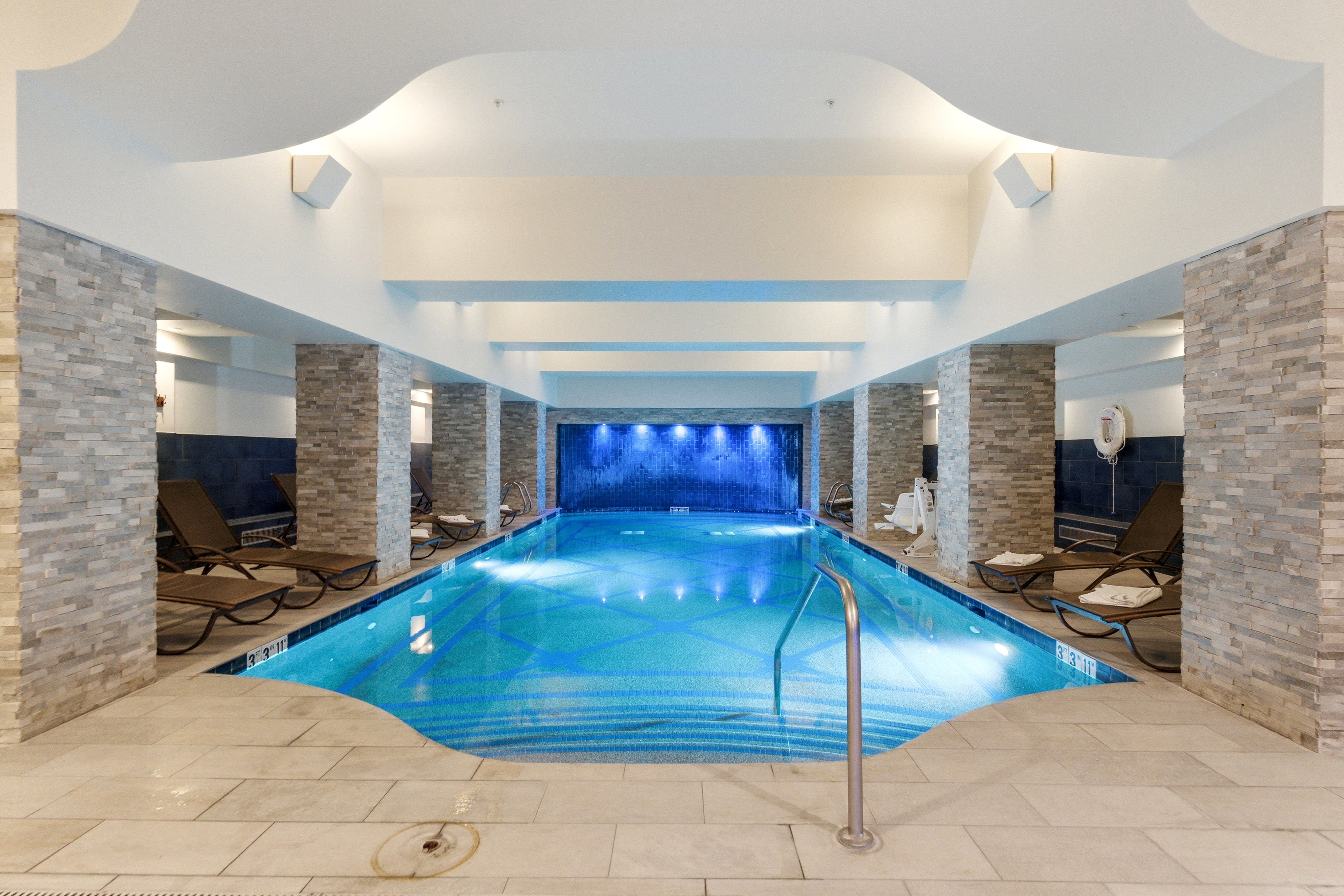 Indoor lap pool featuring a tiled bottom and integrated lighting