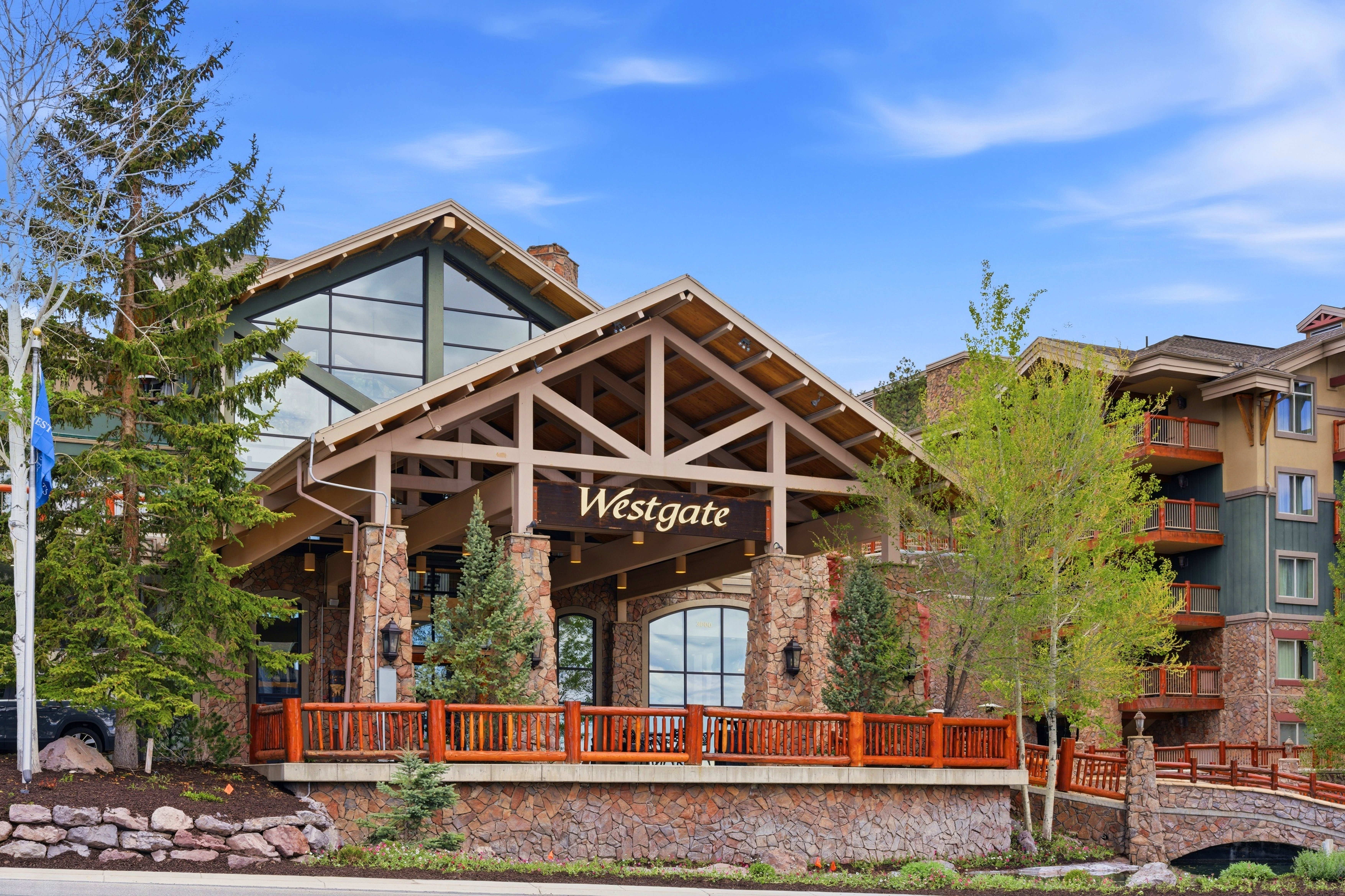 Rustic lodge-style architecture featuring a prominent stone facade and exposed timber framing