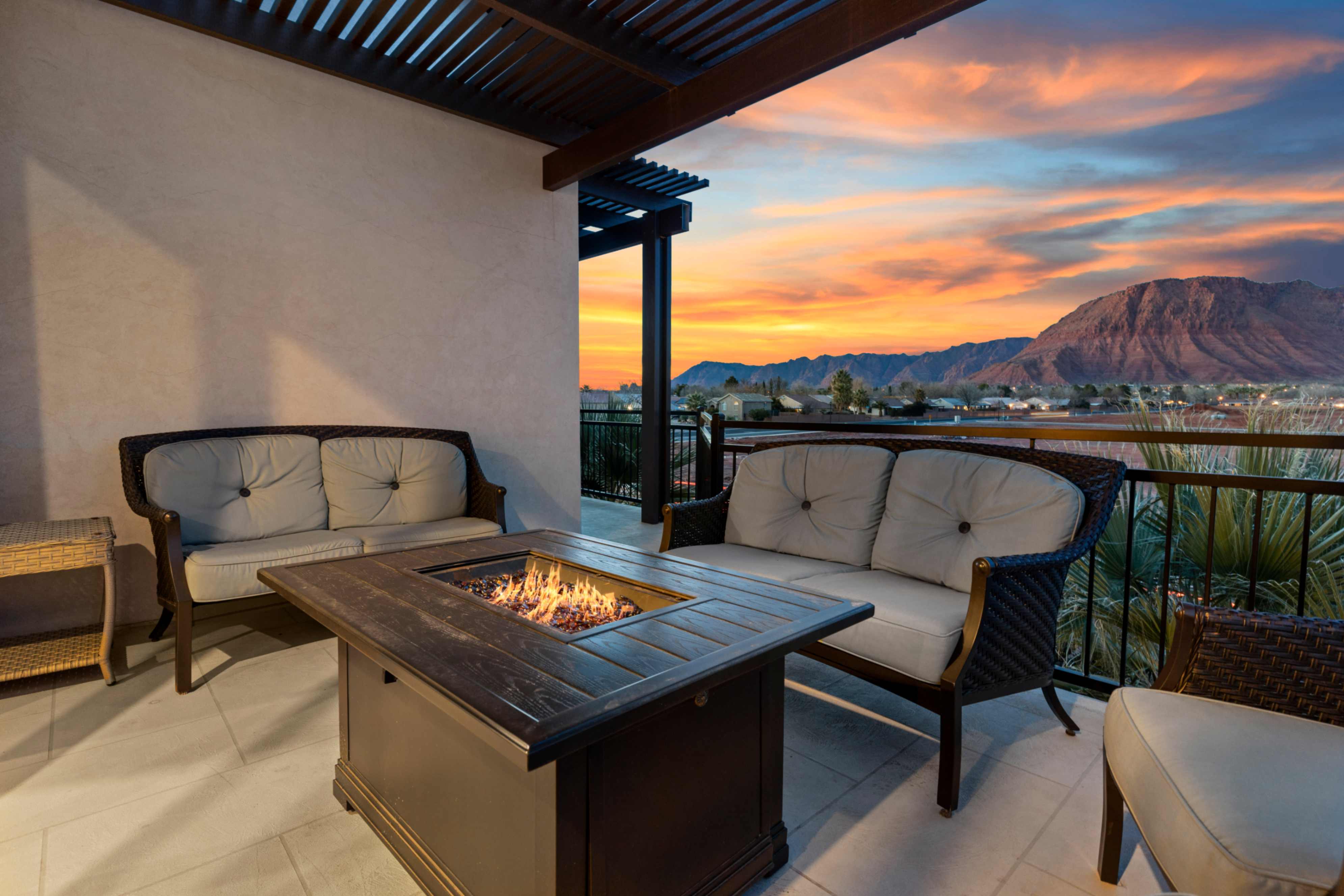 Covered patio with a mounted pergola, tile flooring, stucco wall, and metal railing