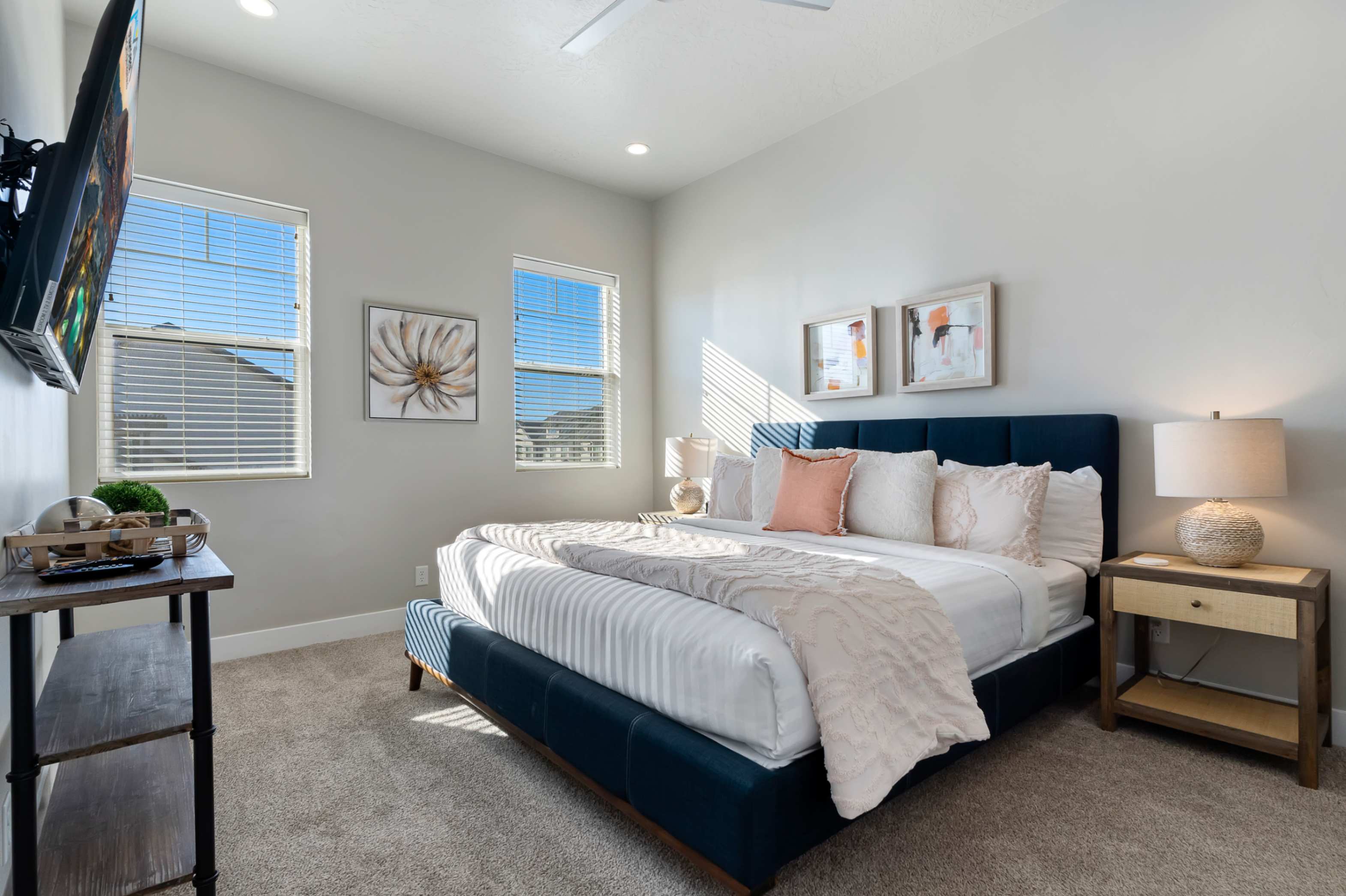 Carpeted bedroom featuring light gray walls, two windows with horizontal blinds, recessed lighting, and a ceiling fan