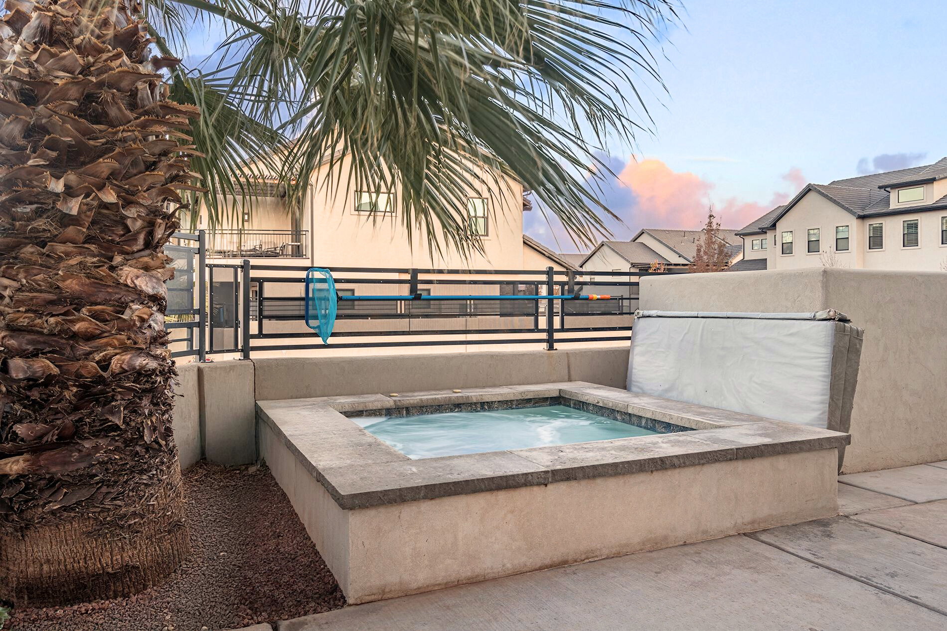 In-ground hot tub with stone coping and stucco surround