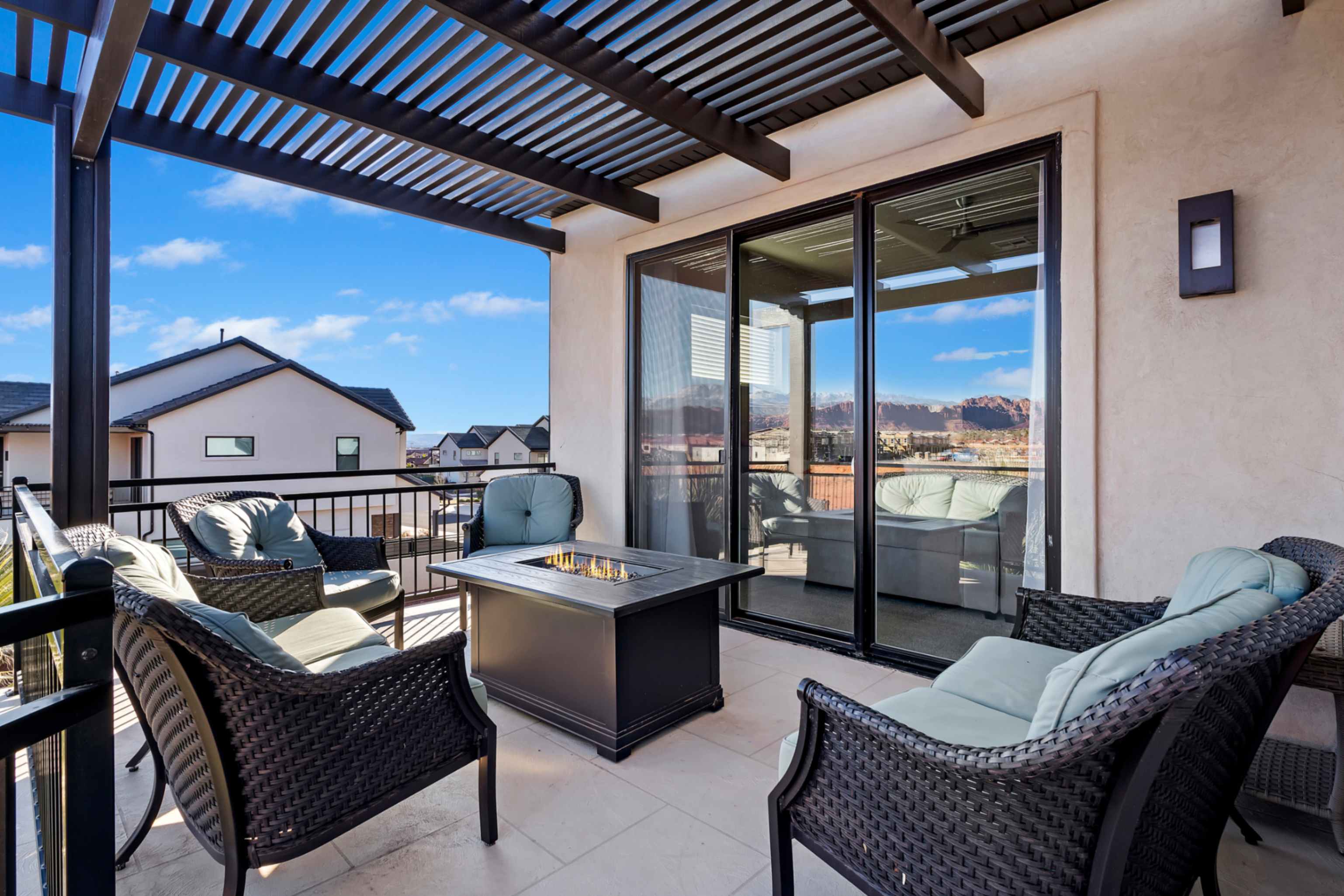 Outdoor patio featuring a slatted pergola, tile flooring, and a black metal railing