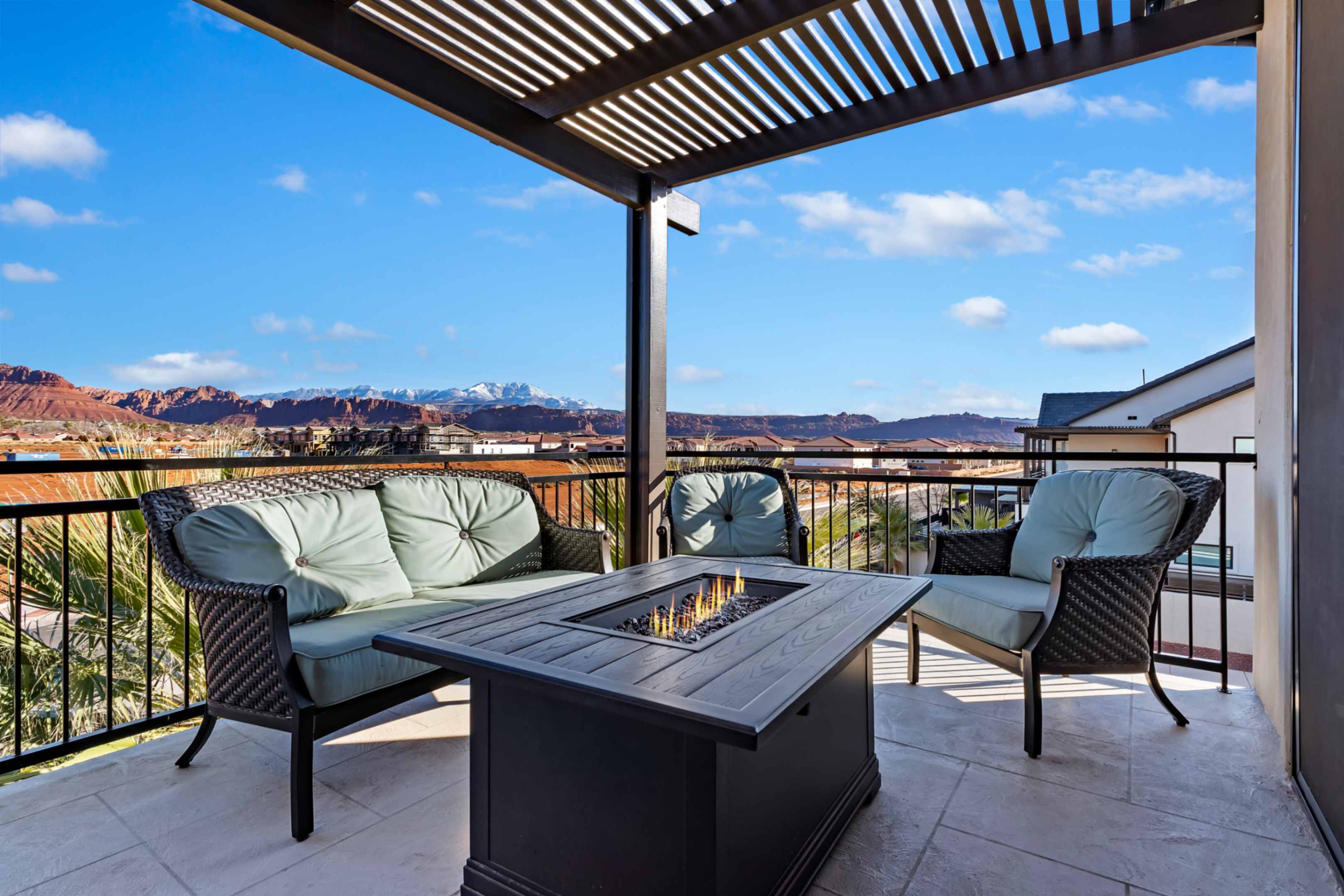 Outdoor patio featuring a black metal pergola, tiled flooring, and a built-in fire table