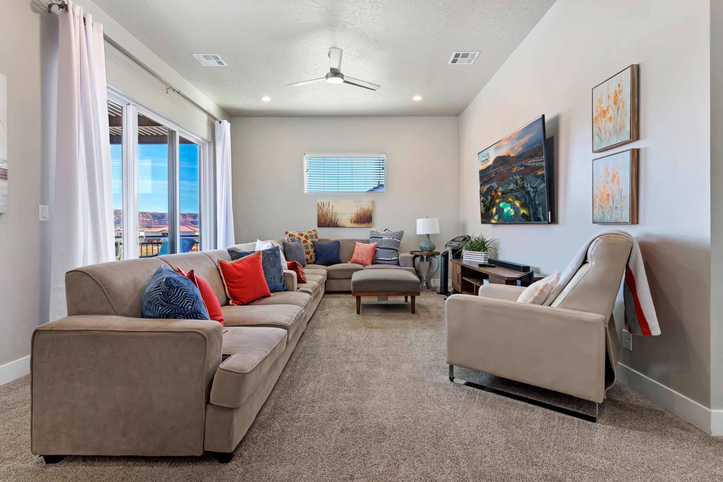 Spacious living area featuring light gray walls, recessed lighting, and a contemporary ceiling fan
