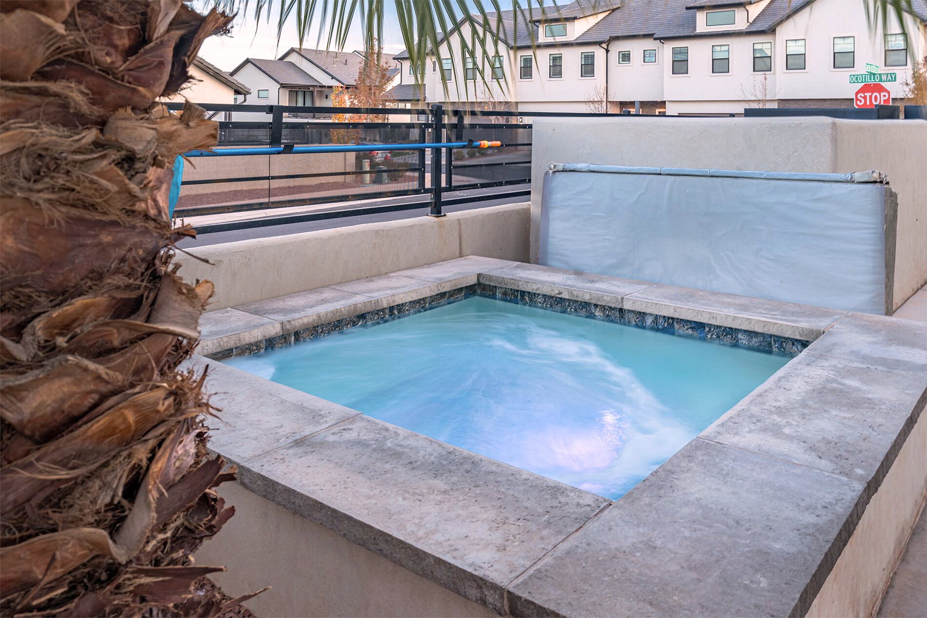 In-ground spa with stone coping and blue tile surround
