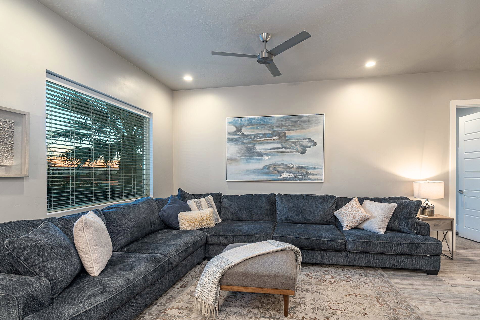Living area featuring recessed lighting, a ceiling fan, and a large window with horizontal blinds