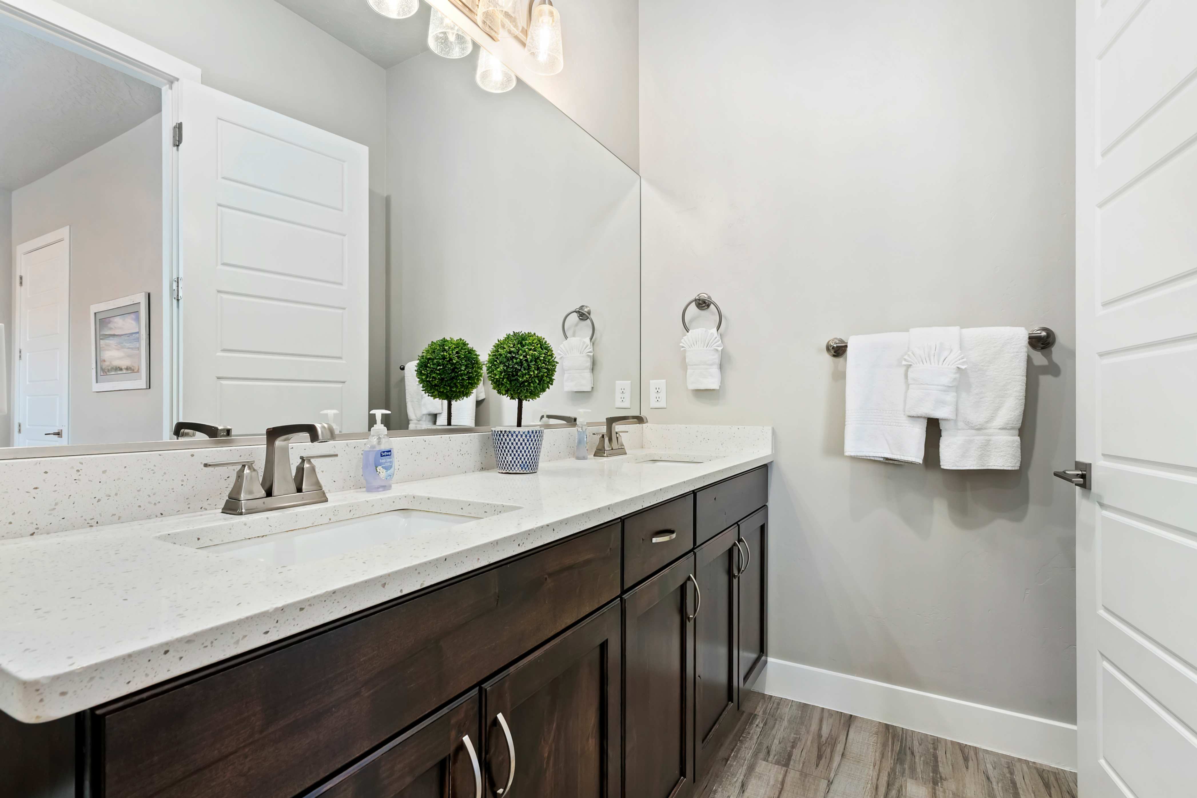 Bathroom featuring a dual vanity with light-colored countertops, dark wood-finish cabinetry, and brushed nickel fixtures