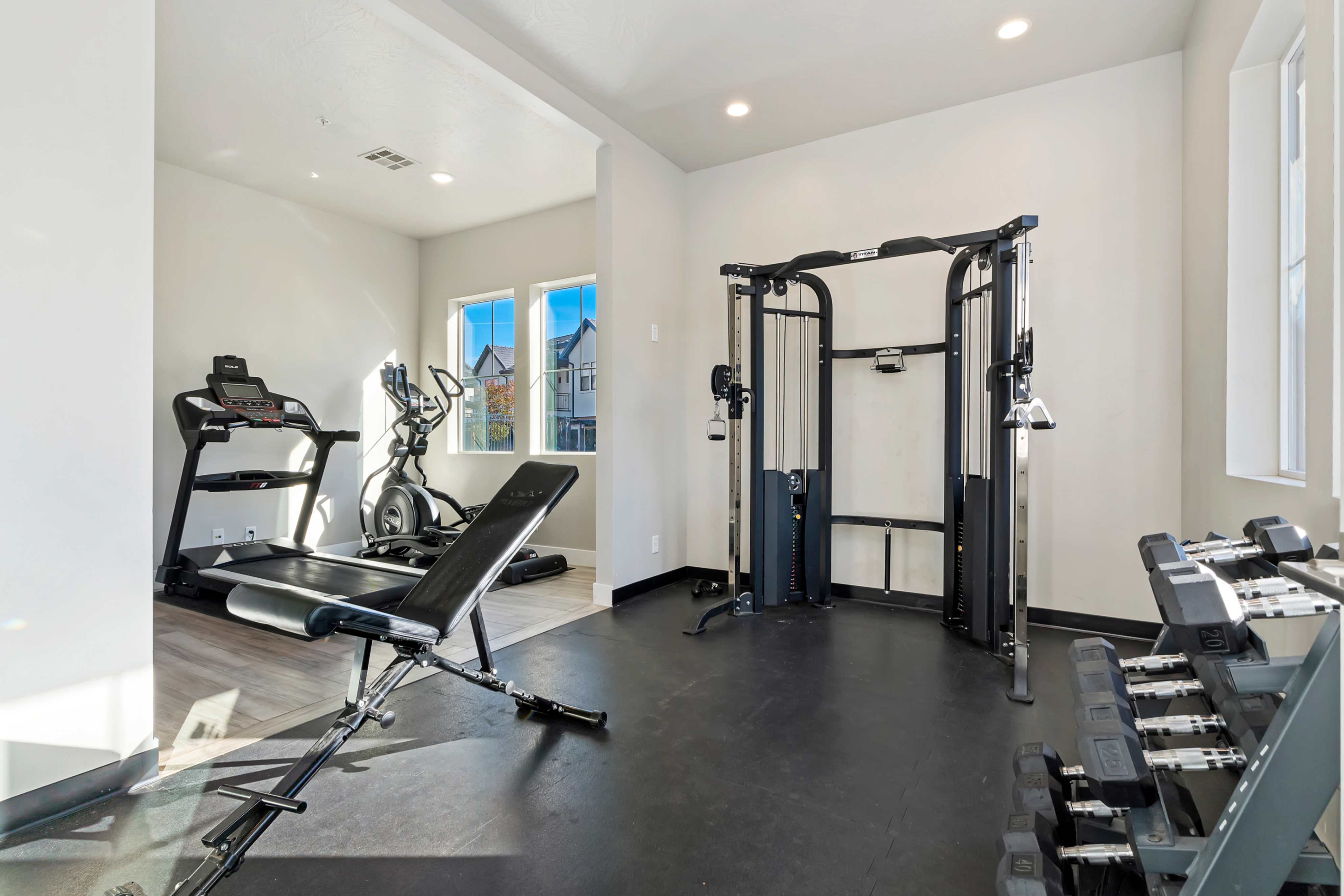 Dedicated fitness space featuring rubber flooring, recessed lighting, and multiple windows
