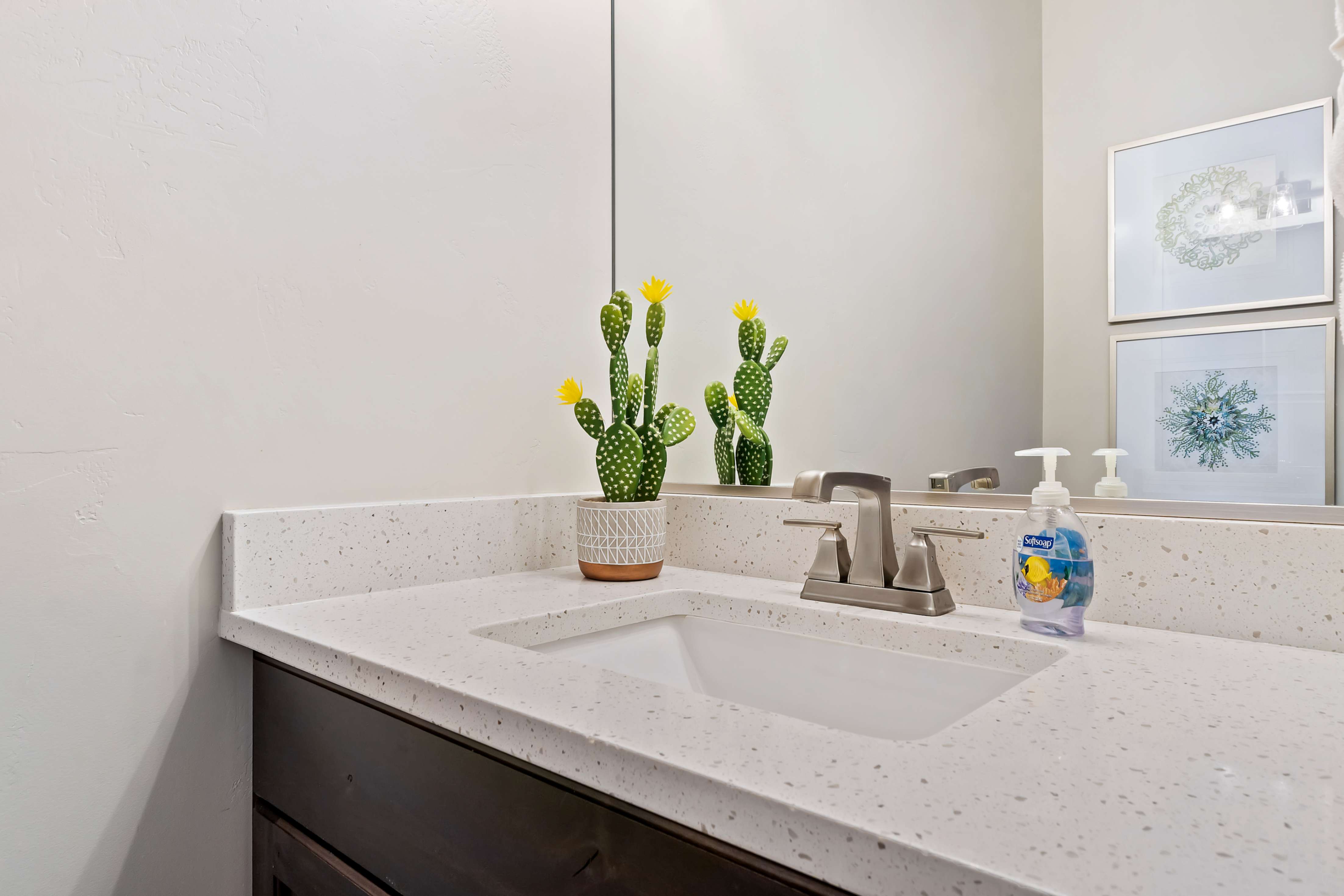 Vanity with an integrated rectangular sink, light speckled countertop, dark wood-finish cabinetry, and a brushed nickel faucet
