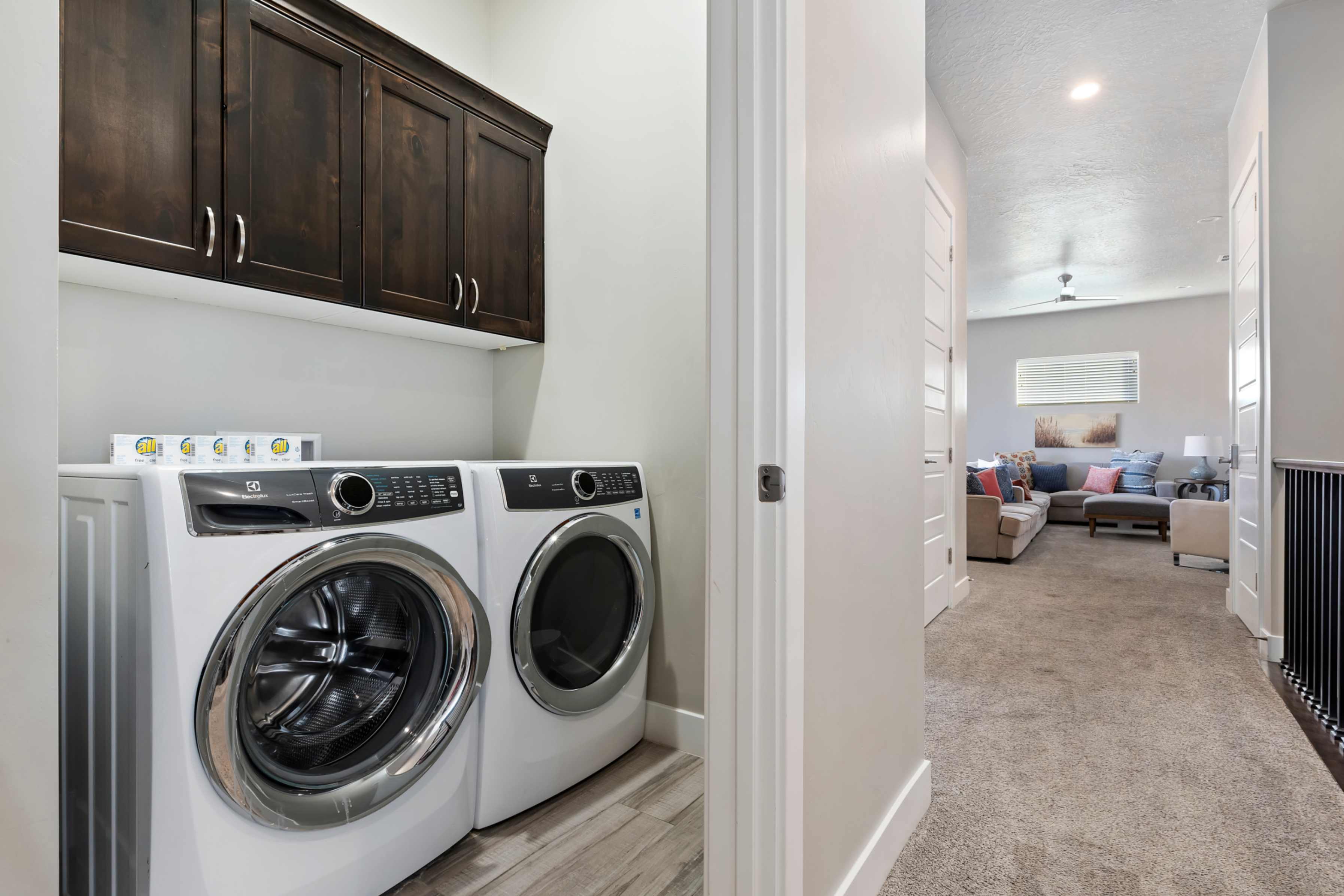 Dedicated laundry area featuring dark wood-finish cabinetry