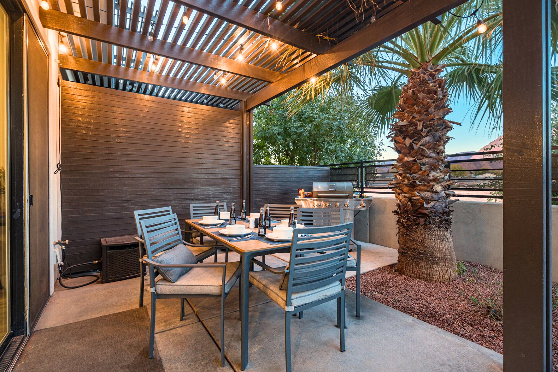 Covered patio featuring a wood slat pergola, string lighting, and concrete flooring