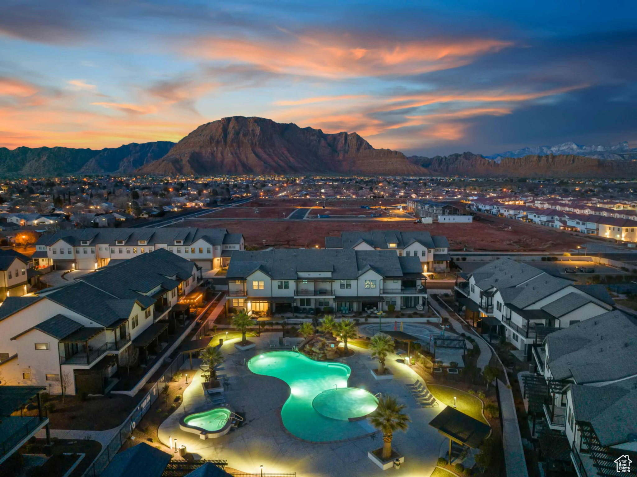 Resort-style community pool and spa surrounded by multiple multi-story residential buildings, with a prominent mountain backdrop