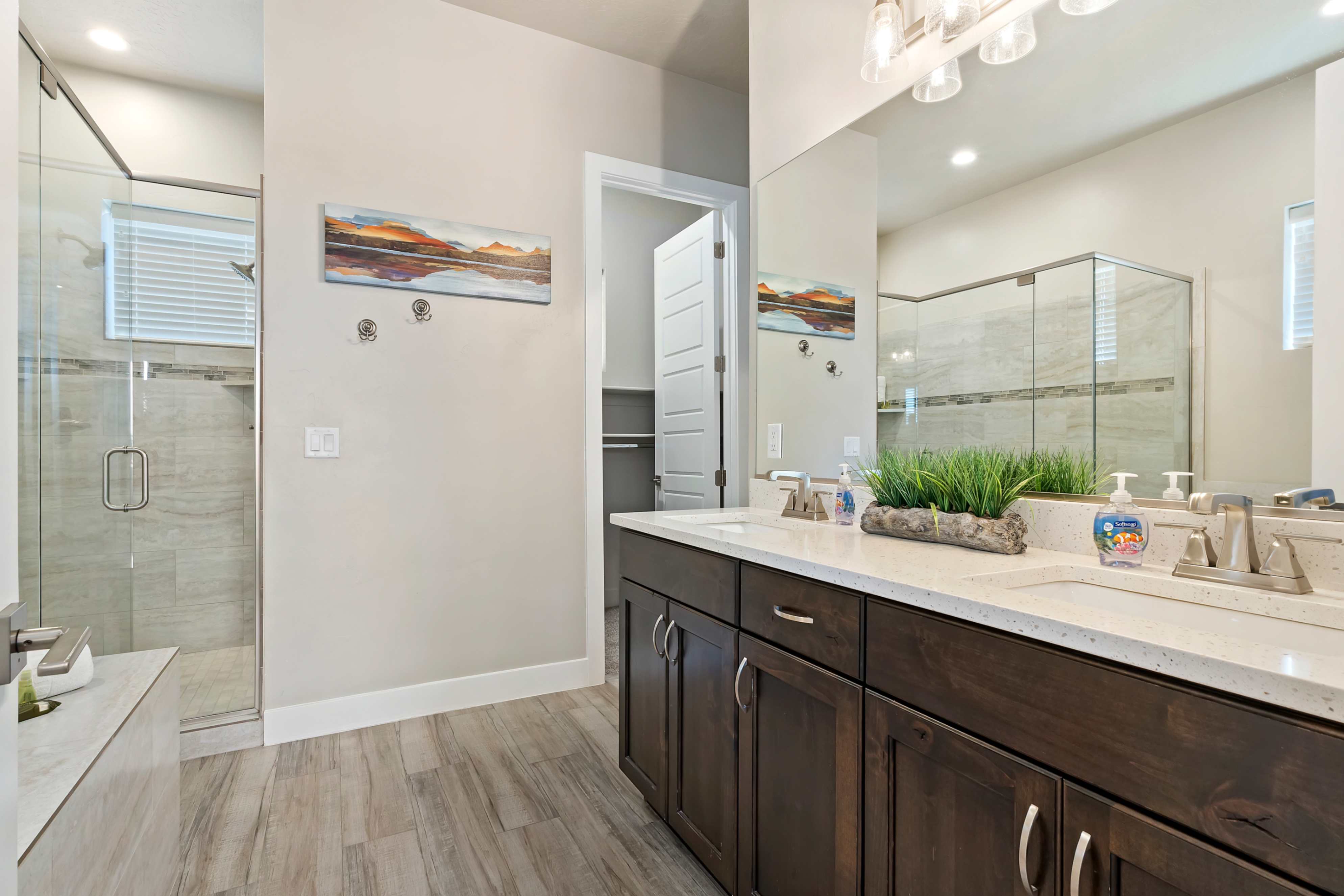 Bathroom featuring a dual vanity with dark wood cabinetry and light-toned countertops