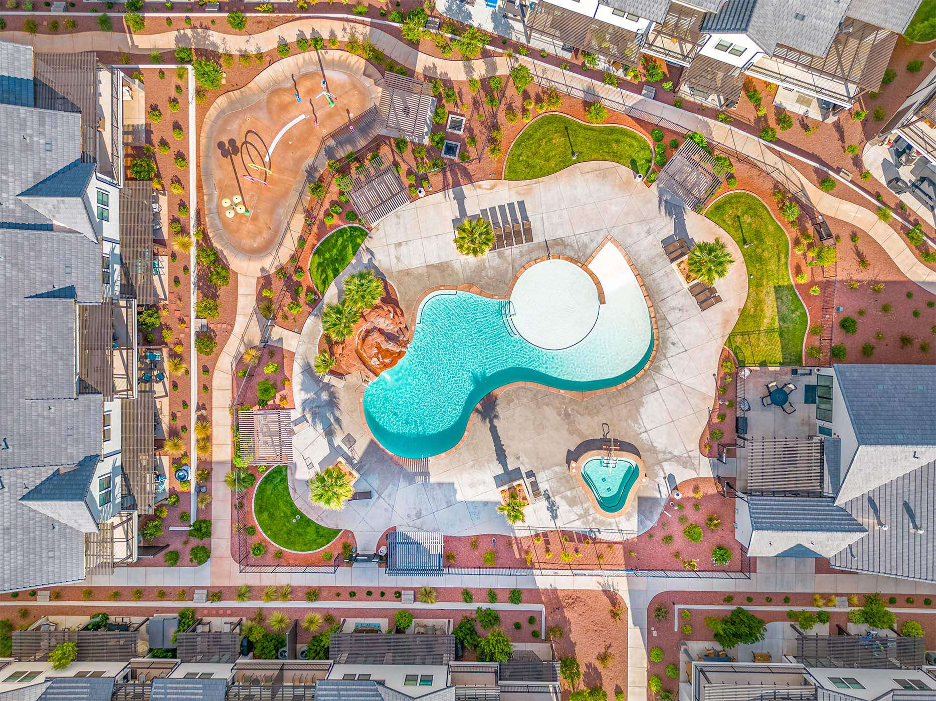 Community recreation area featuring a freeform swimming pool, integrated spa, and expansive concrete sundeck