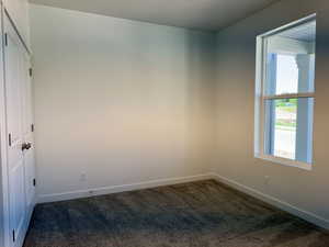 Neutral interior space featuring white walls and a carpeted floor