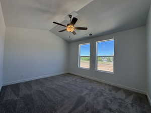 Carpeted interior space featuring a vaulted ceiling and a ceiling fan with integrated lighting