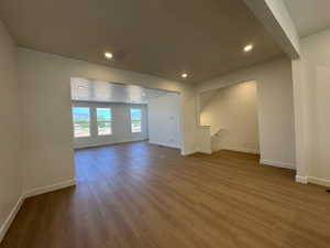 Spacious interior featuring wood-finish flooring throughout, recessed lighting, and white baseboards