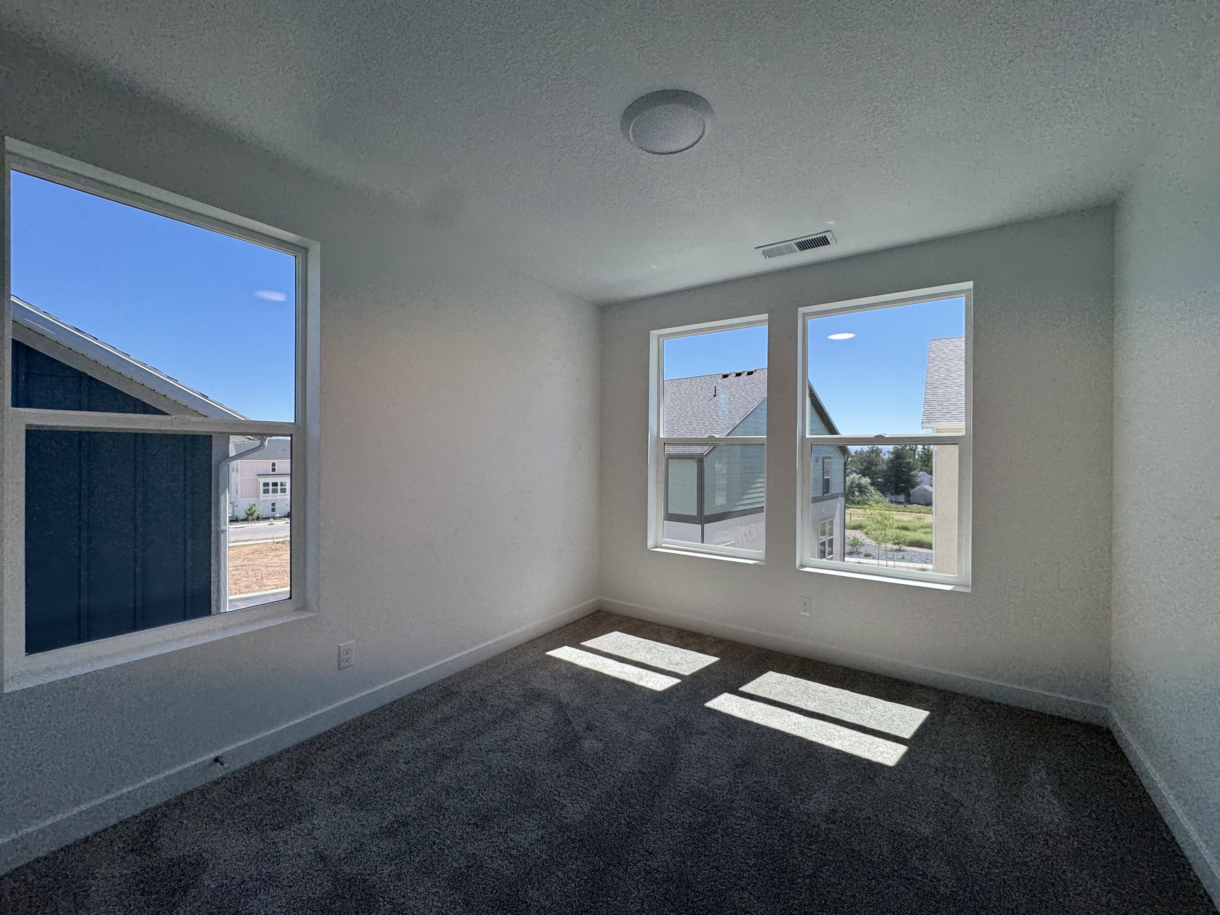 Bright room featuring plush carpet flooring, white baseboards, and neutral wall tones