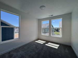 Bright room featuring plush carpet flooring, white baseboards, and neutral wall tones
