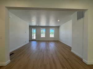 Spacious interior with wood-finish flooring, recessed lighting, and white baseboards