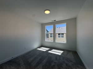 Room featuring neutral-toned walls, gray patterned carpet, and two double-hung windows providing natural light
