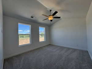 Spacious room featuring vaulted ceilings and a ceiling fan with integrated lighting