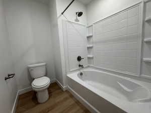 Crisp white bathtub and shower surround with integrated shelving, complemented by oil-rubbed bronze fixtures