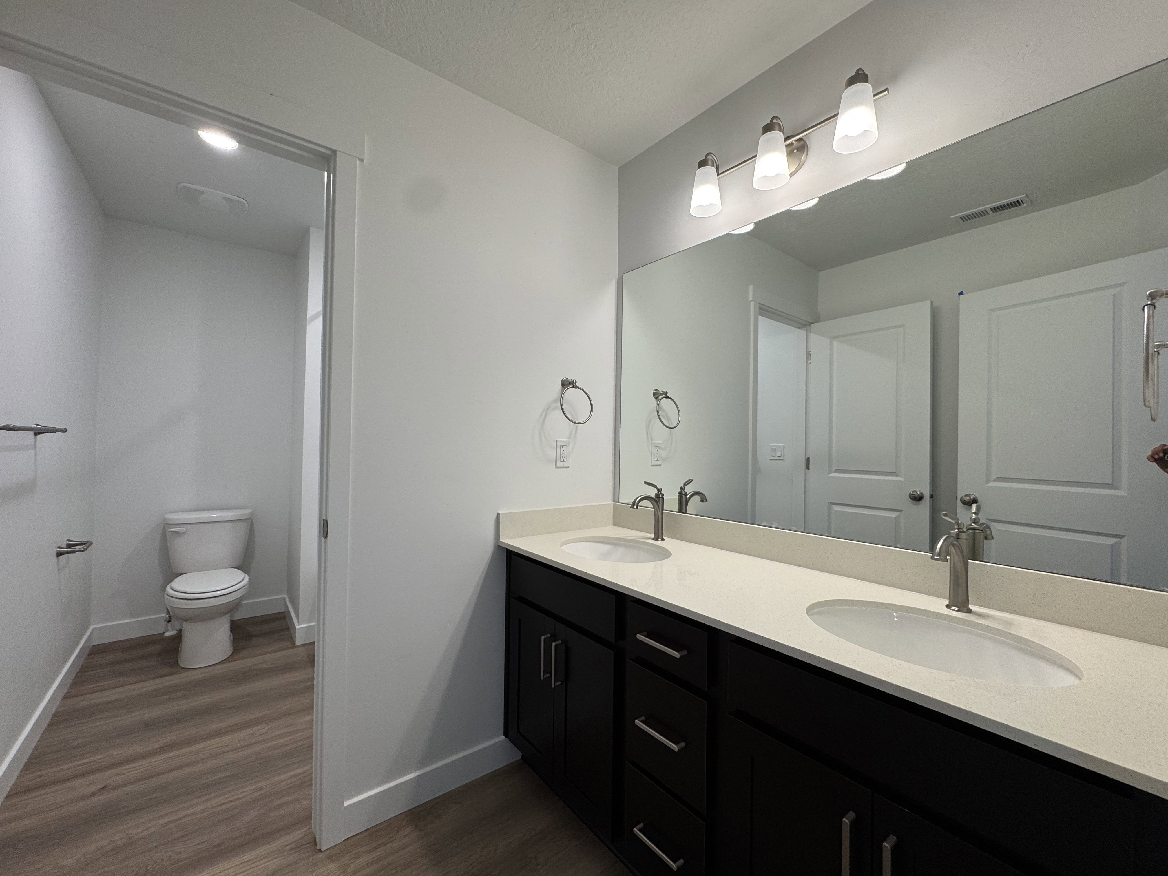 Dual vanity featuring stone-finish countertops, undermount sinks, and brushed nickel faucets