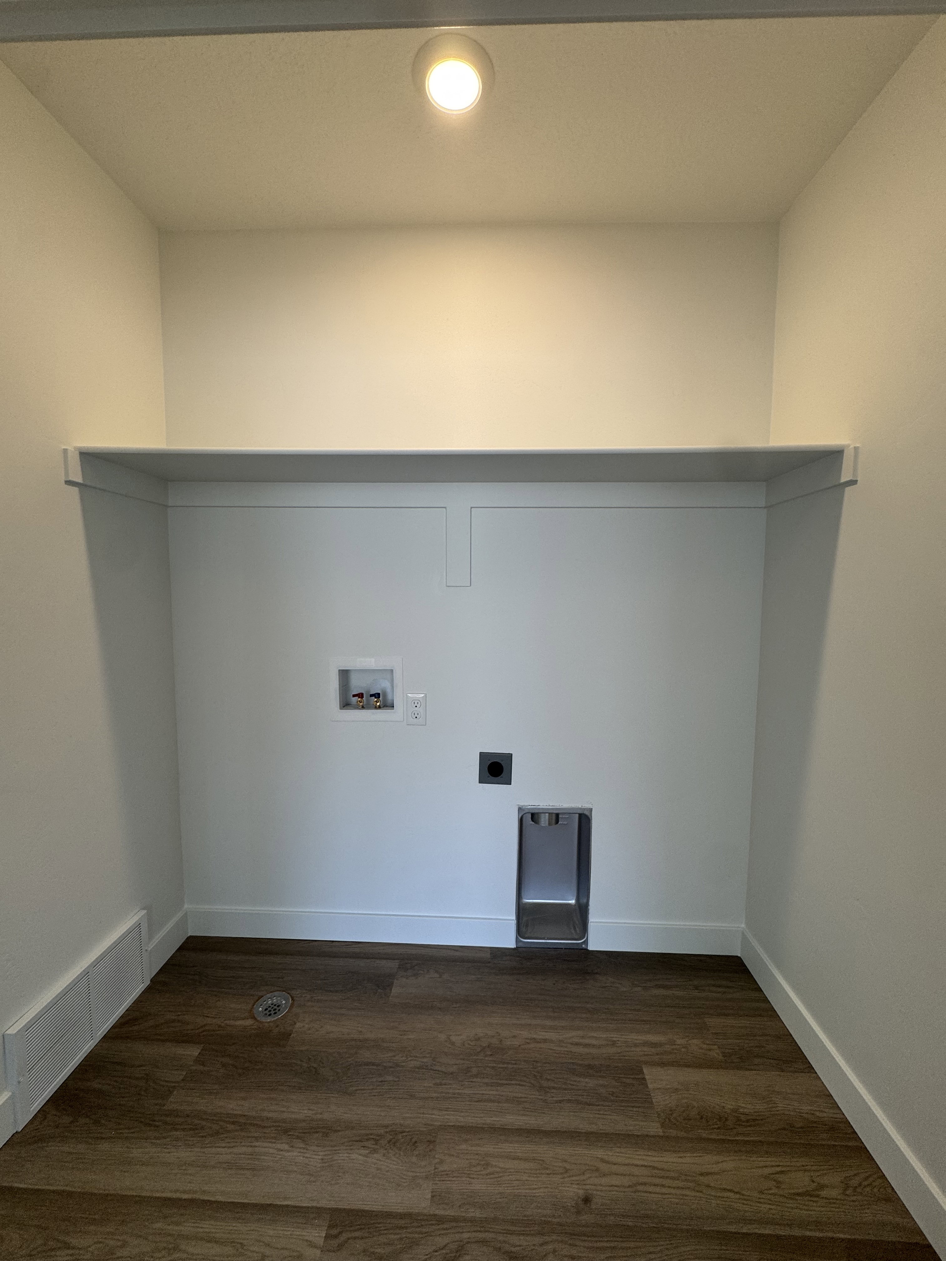 Laundry area featuring wood-finish flooring, a built-in shelf, and recessed lighting