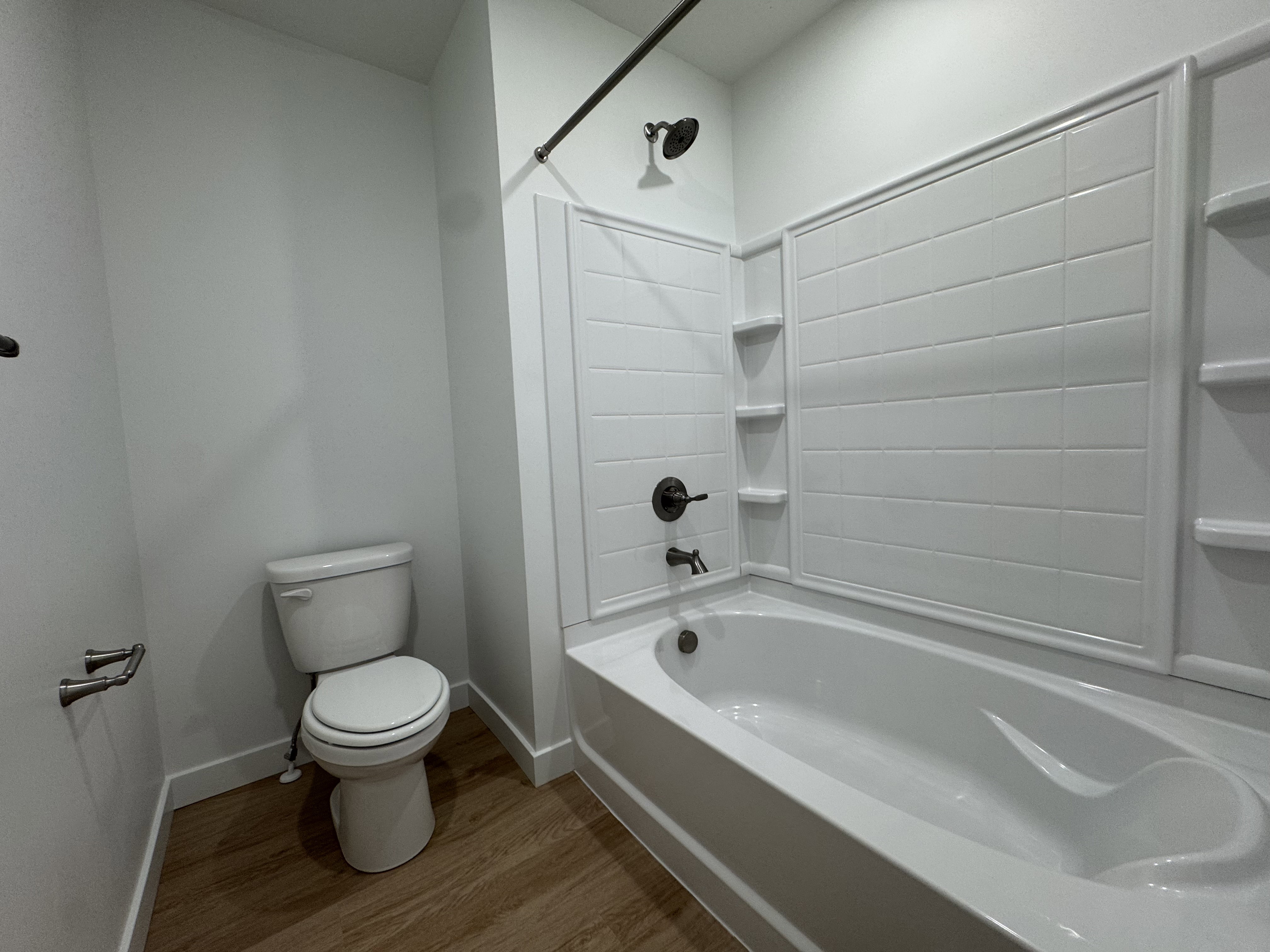 Tub and shower combination featuring a dark bronze showerhead and faucet