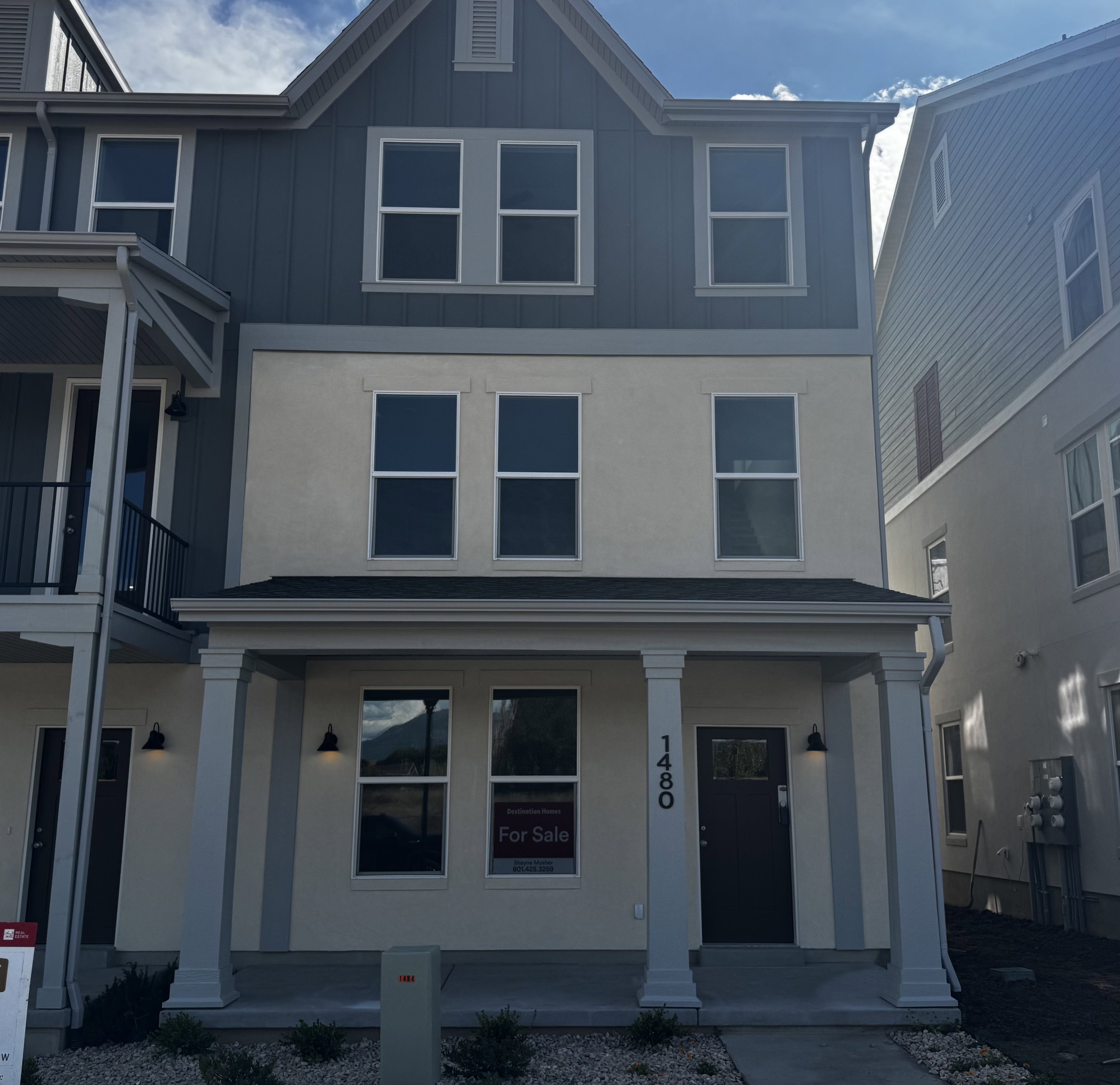 Contemporary townhome with a multi-level facade featuring vertical siding and stucco finishes
