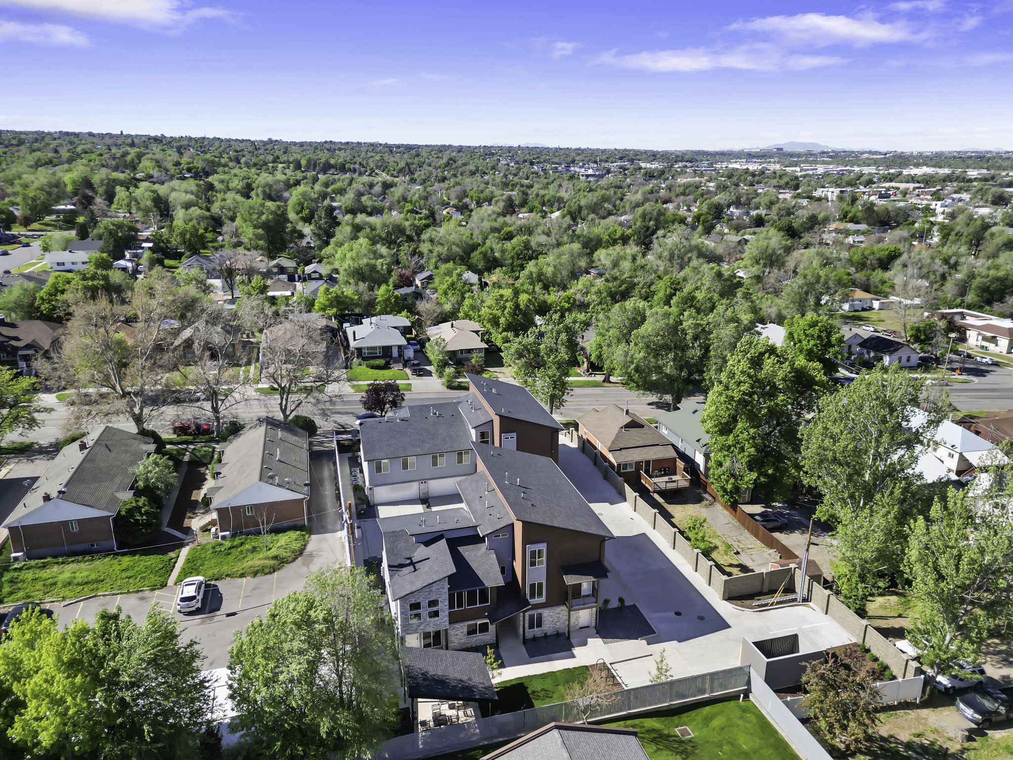 Modern architectural multi-unit property featuring dark siding and light stone accents