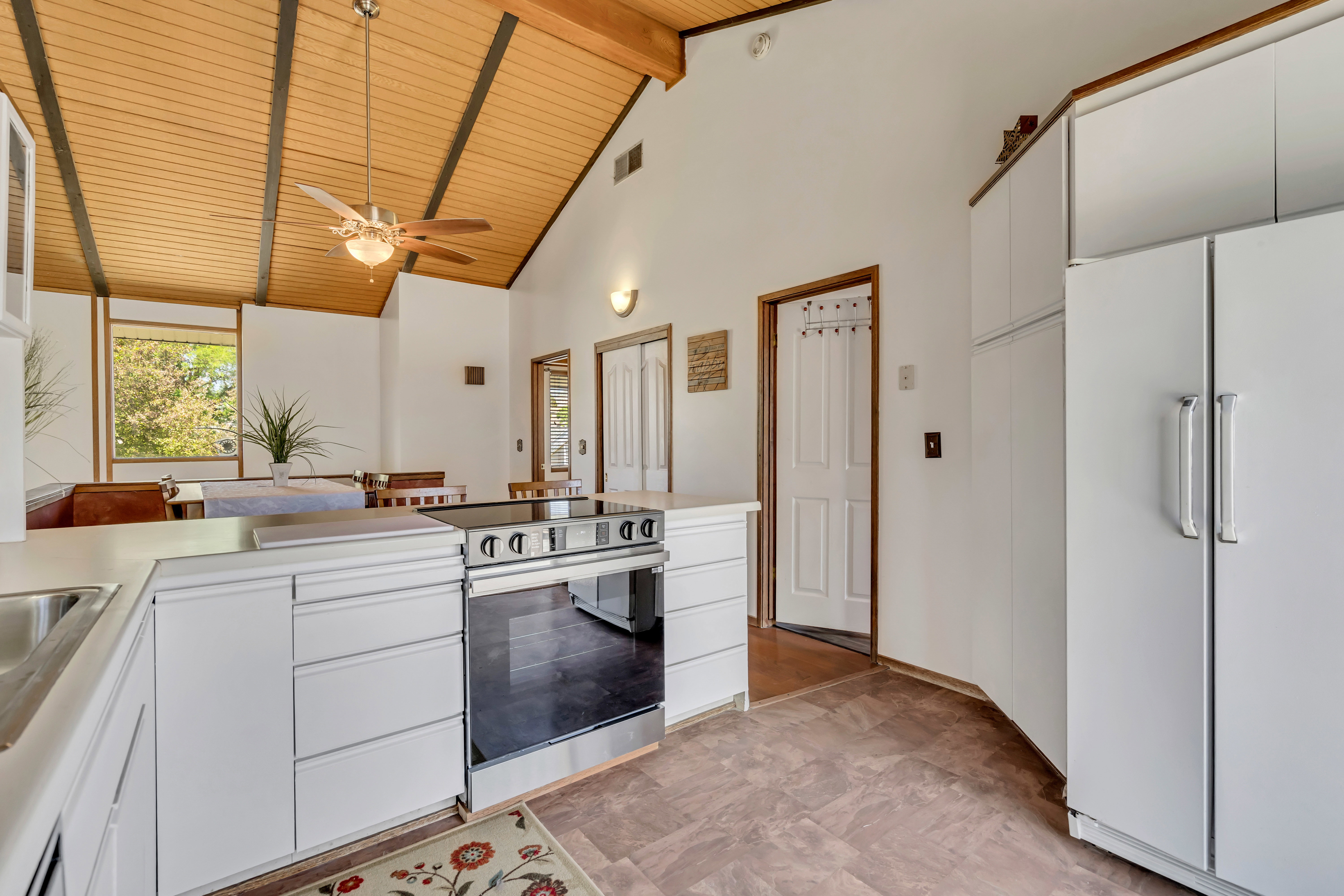 Kitchen featuring white cabinetry, stainless steel range, and a built-in refrigerator