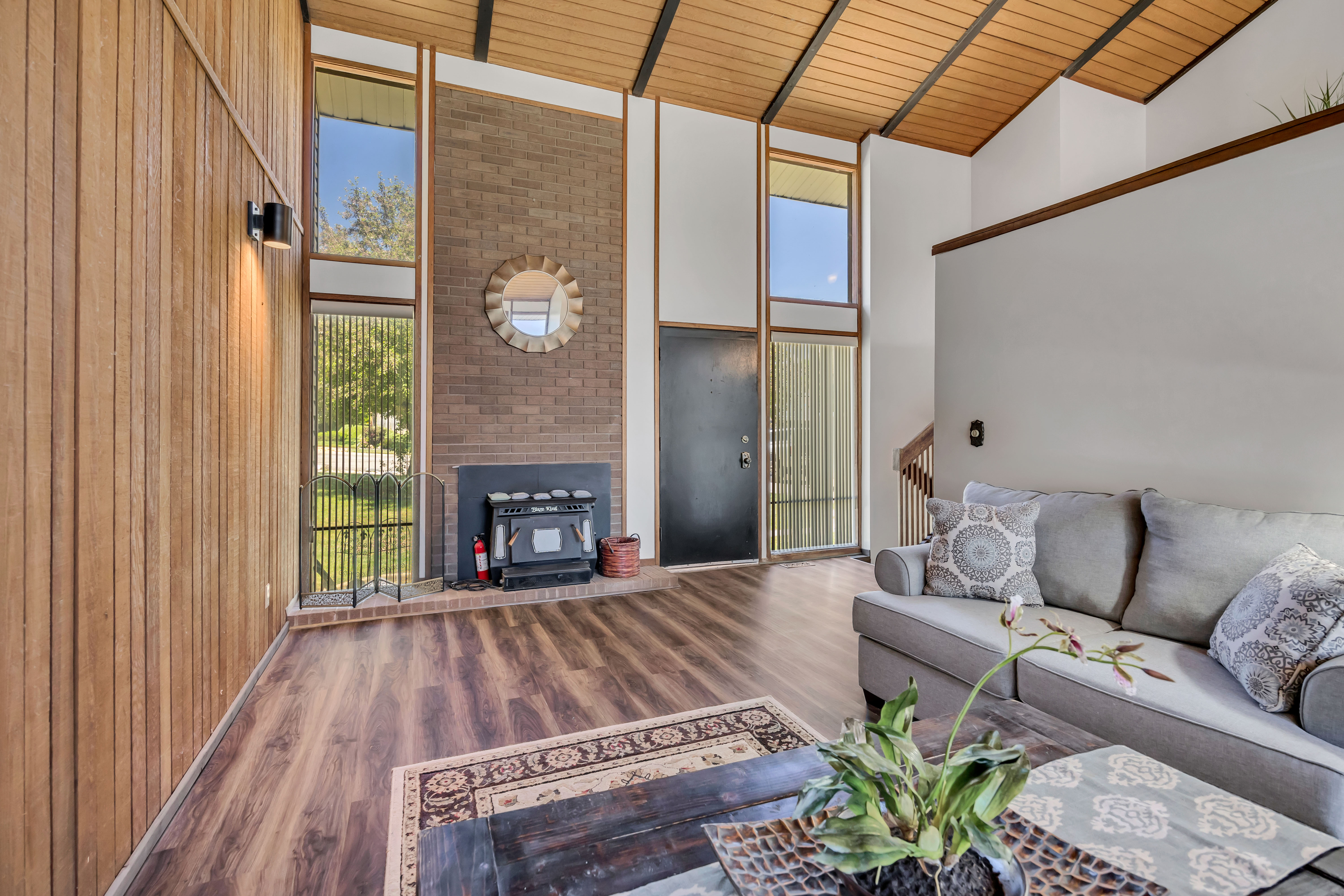 Expansive living area featuring a vaulted wood-paneled ceiling, exposed beams, and durable wood-finish flooring