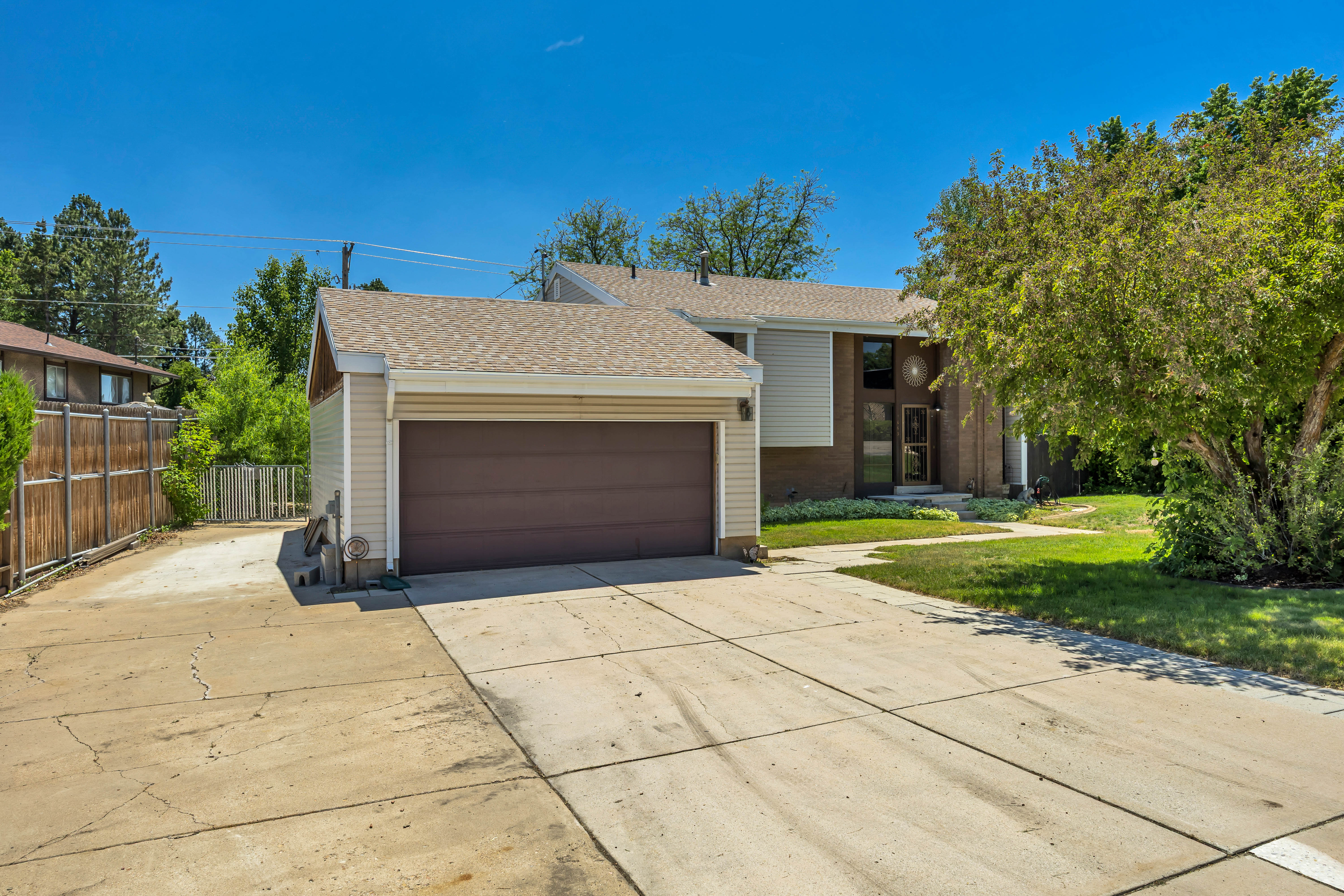 Split-level residence featuring a two-car attached garage with a brown door