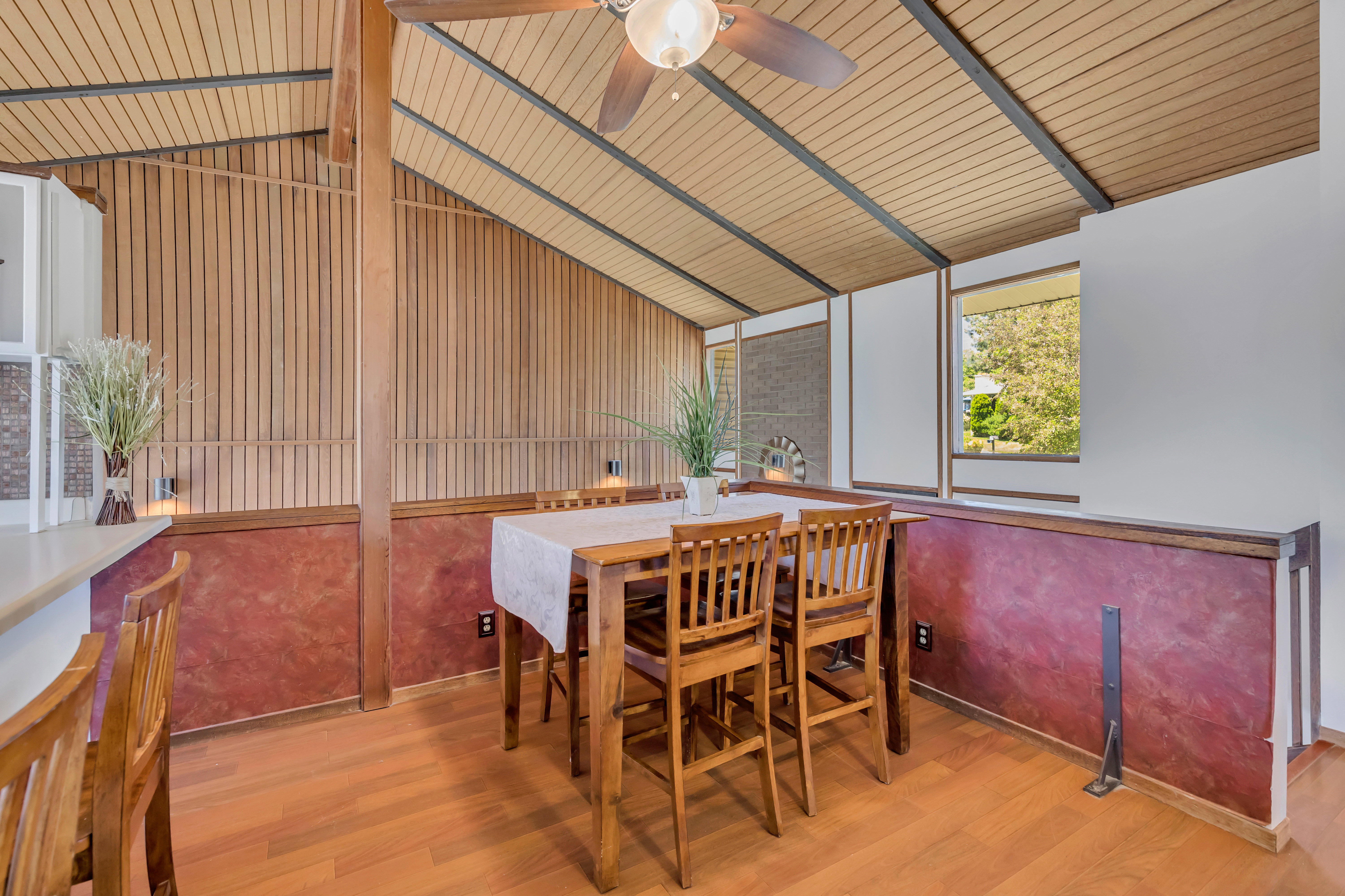 Dining area featuring a vaulted wood-finish ceiling, exposed beams, and perimeter windows
