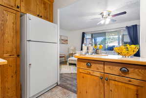Kitchen with natural wood cabinetry and a white refrigerator