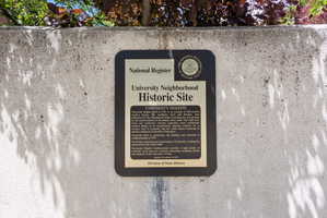 Historic Site plaque mounted on a textured concrete wall, featuring a National Register of Historic Places seal