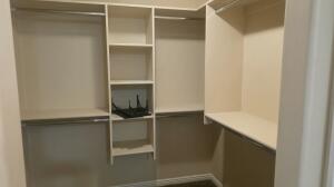 Custom-built closet system featuring multiple hanging rods, integrated shelving units, and ample storage capacity