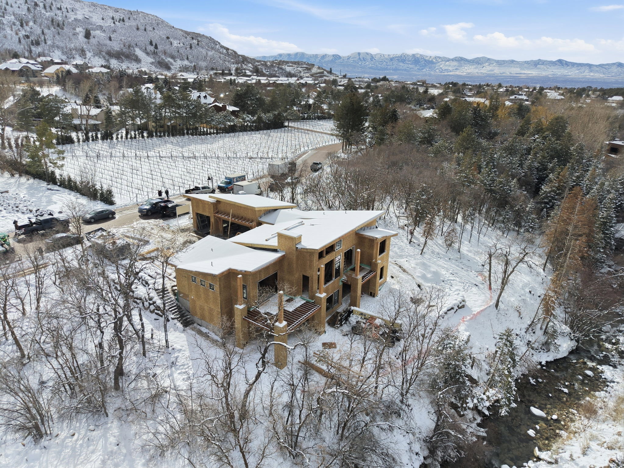 Expansive property featuring a multi-level structure under construction with a sloped roofline, multiple balconies, and a stone facade