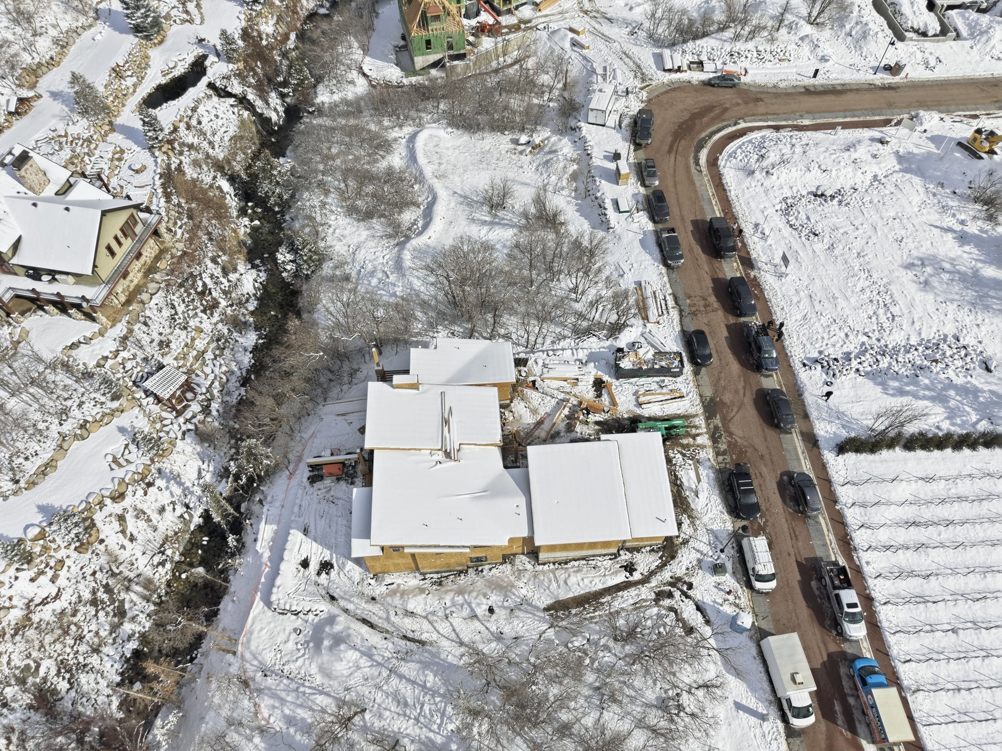 New construction site featuring wood framing and a snow-covered roof